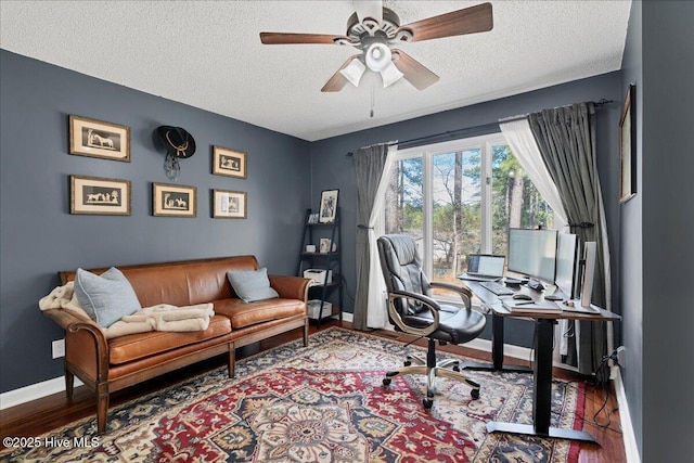 home office featuring a textured ceiling, wood finished floors, a ceiling fan, and baseboards