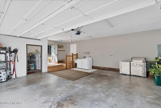 garage with baseboards, a garage door opener, and washing machine and clothes dryer