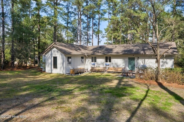 back of property featuring board and batten siding and a lawn