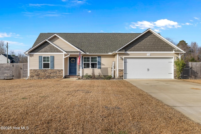 craftsman house with a front yard, stone siding, fence, and concrete driveway