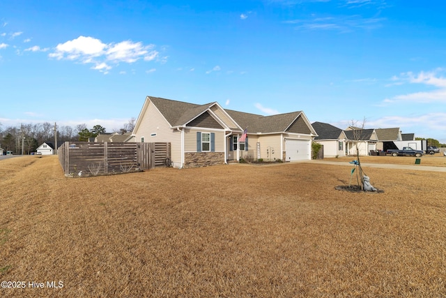 single story home with a garage, a residential view, fence, and a front yard