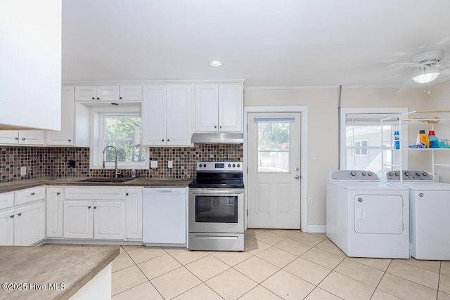 kitchen with washing machine and dryer, under cabinet range hood, a sink, stainless steel electric range, and dishwasher