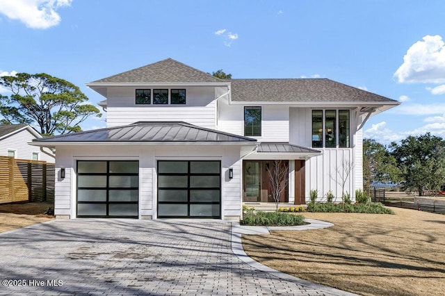 view of front of home with metal roof, a garage, fence, decorative driveway, and a standing seam roof