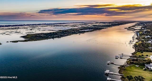 aerial view at dusk featuring a water view