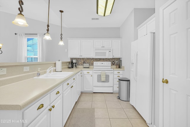 kitchen with white appliances, light countertops, a sink, and decorative light fixtures