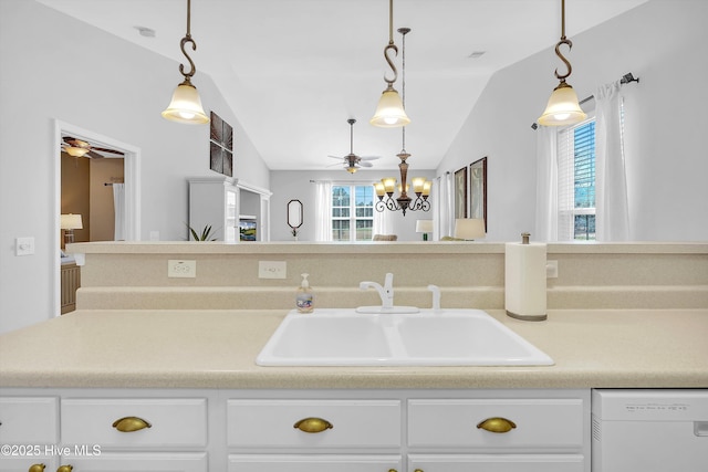 kitchen featuring a wealth of natural light, white dishwasher, a sink, and decorative light fixtures