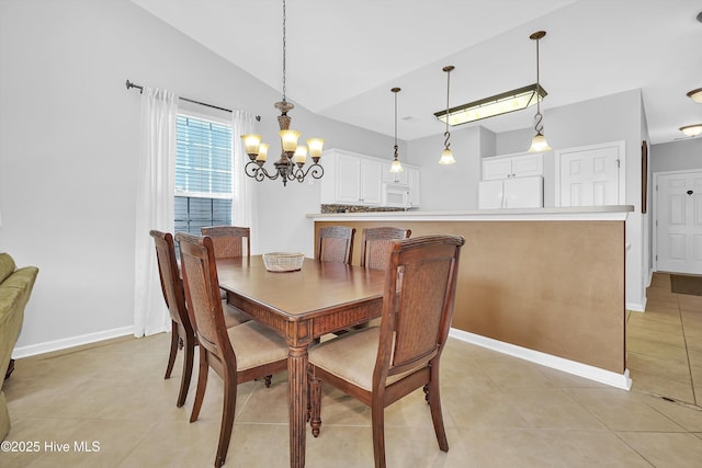 dining area featuring light tile patterned flooring, vaulted ceiling, a notable chandelier, and baseboards