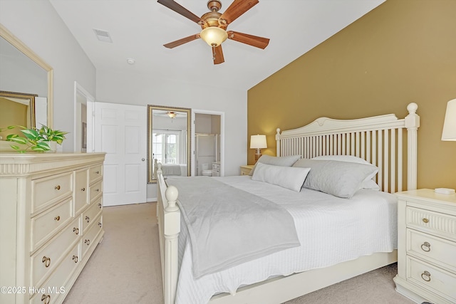 bedroom with visible vents, ensuite bathroom, light carpet, ceiling fan, and vaulted ceiling