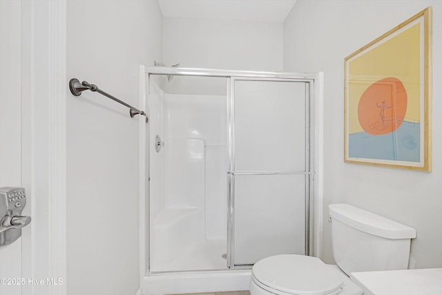 bathroom with a shower stall and toilet