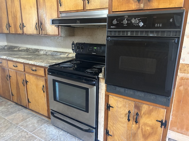 kitchen featuring brown cabinetry, stainless steel range with electric cooktop, under cabinet range hood, and black oven