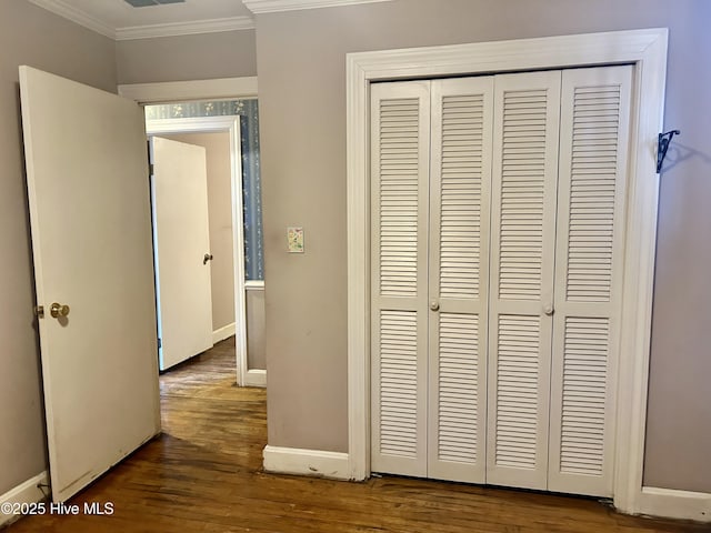 hall featuring dark wood-style floors, ornamental molding, visible vents, and baseboards