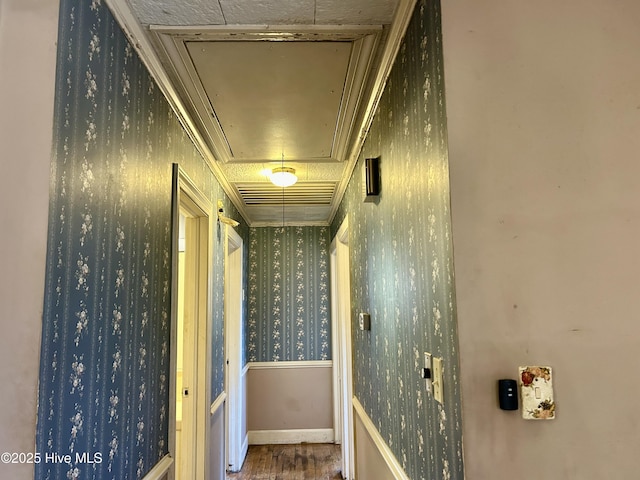 hallway with baseboards, wood finished floors, attic access, and wallpapered walls