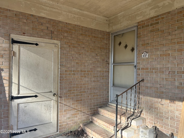 doorway to property with brick siding