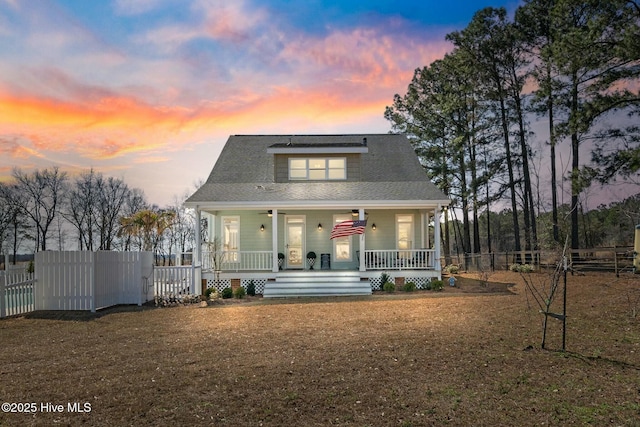 back of property with a porch and a fenced front yard