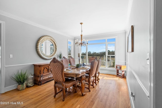 dining space featuring a notable chandelier, light wood-style flooring, and crown molding