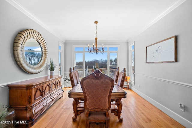 dining room featuring ornamental molding, light wood-style flooring, and baseboards