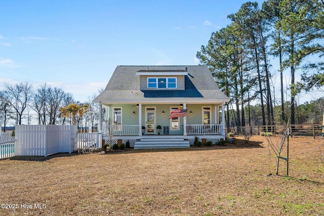 view of front facade featuring a fenced front yard, a front yard, and covered porch