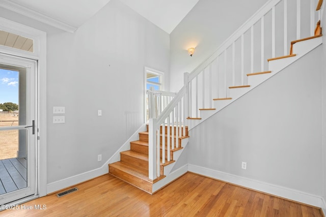 stairs with visible vents, baseboards, and wood finished floors