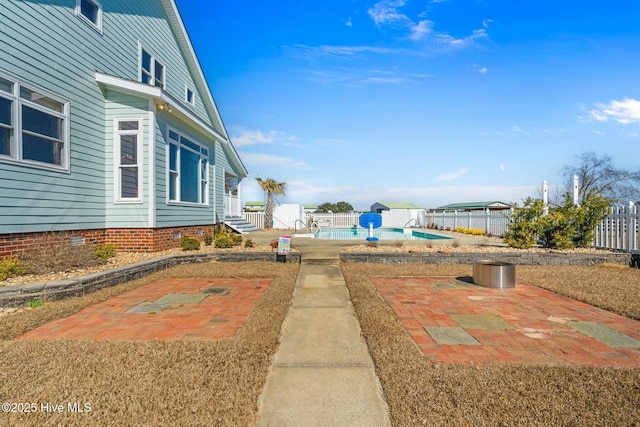 view of yard with a patio area, fence, and a fenced in pool