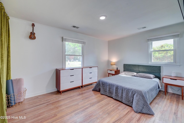 bedroom featuring multiple windows, visible vents, and wood finished floors