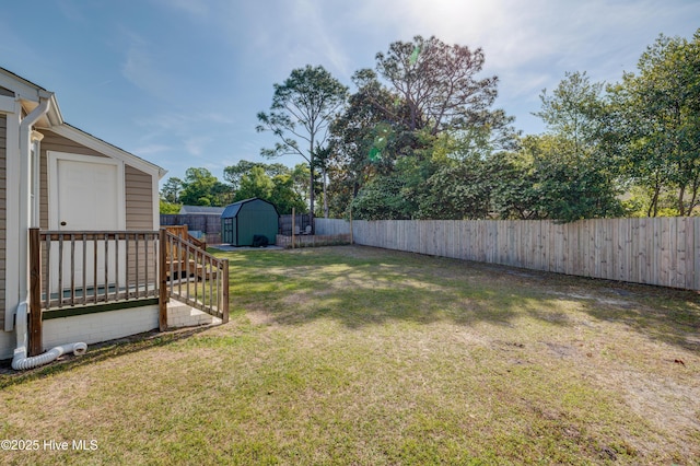 view of yard featuring an outbuilding, a fenced backyard, and a shed