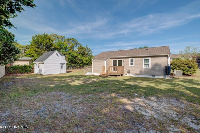 back of house with central air condition unit, an outdoor structure, fence, a wooden deck, and a lawn