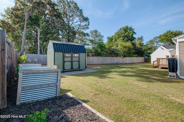 view of yard with a deck, an outbuilding, a shed, and a fenced backyard