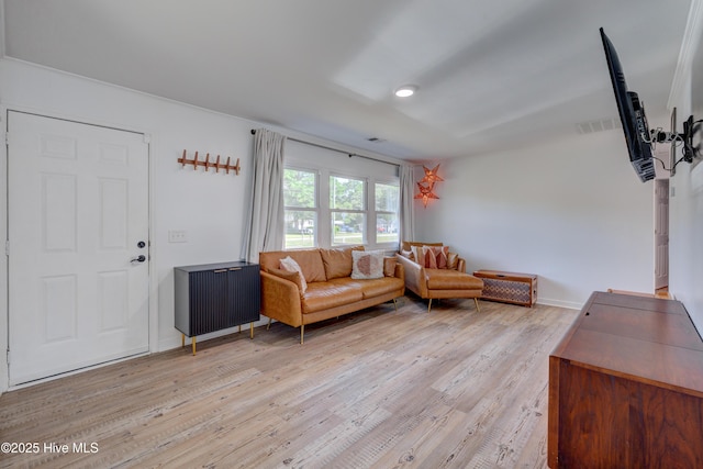 living room with baseboards, light wood-style flooring, and visible vents