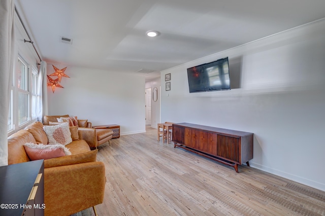living room featuring visible vents, wood finished floors, and baseboards