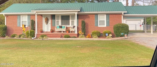 view of front of home with a porch, a front yard, brick siding, and driveway