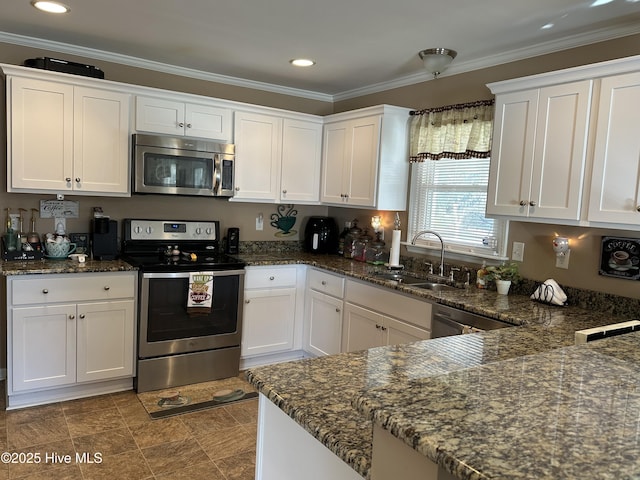 kitchen featuring stainless steel appliances, a sink, white cabinets, dark stone countertops, and crown molding