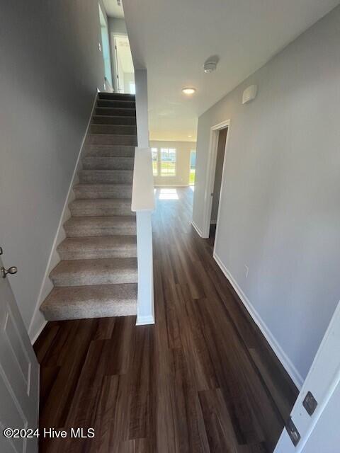 stairway featuring baseboards and wood finished floors