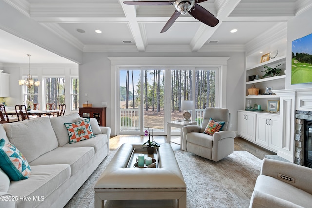 living room with a wealth of natural light, visible vents, beamed ceiling, and a premium fireplace