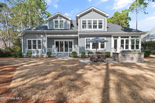 back of property with a patio and roof with shingles