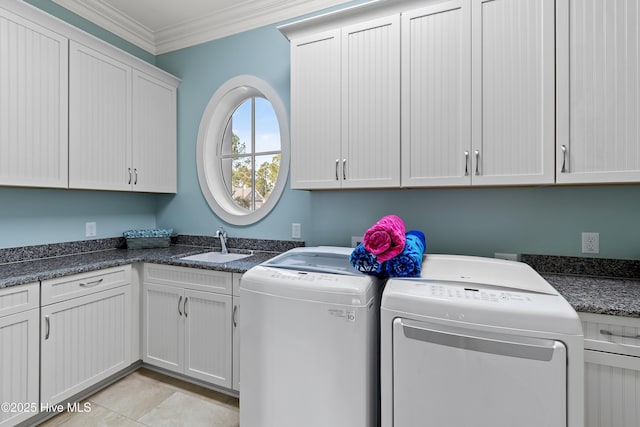 laundry room featuring light tile patterned floors, separate washer and dryer, a sink, ornamental molding, and cabinet space