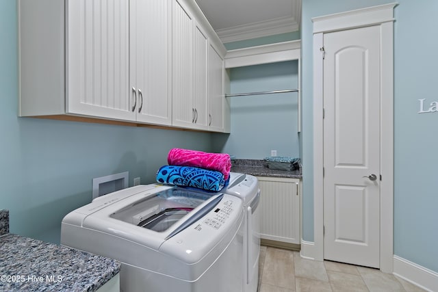 washroom with light tile patterned flooring, separate washer and dryer, baseboards, cabinet space, and crown molding