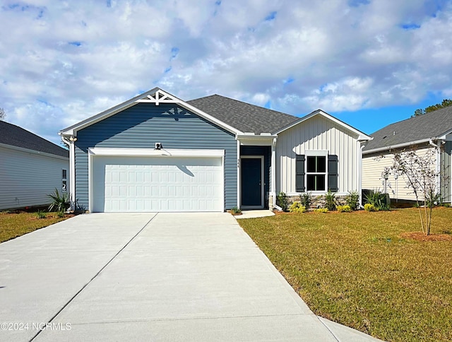 view of front of home featuring an attached garage, a shingled roof, driveway, board and batten siding, and a front yard