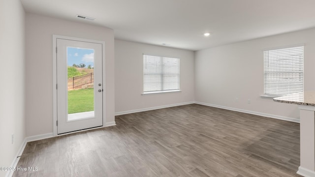 doorway to outside featuring wood finished floors, visible vents, and baseboards