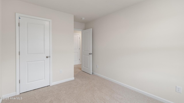 unfurnished bedroom with baseboards and light colored carpet