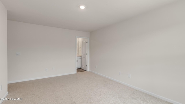 spare room with light carpet, baseboards, and recessed lighting