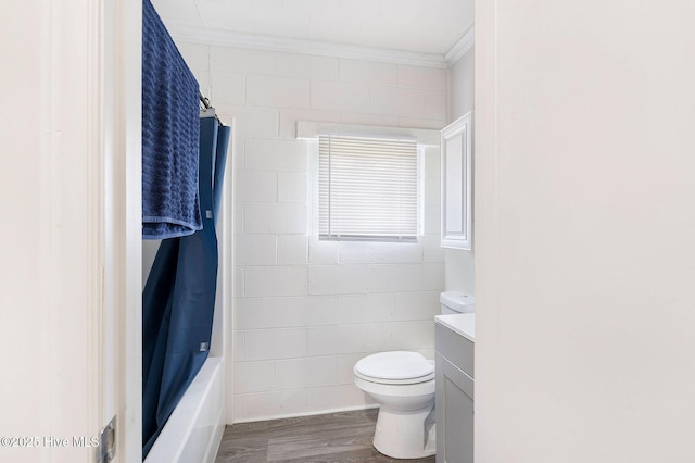 full bath with toilet, ornamental molding, wood finished floors, shower / bath combo with shower curtain, and vanity