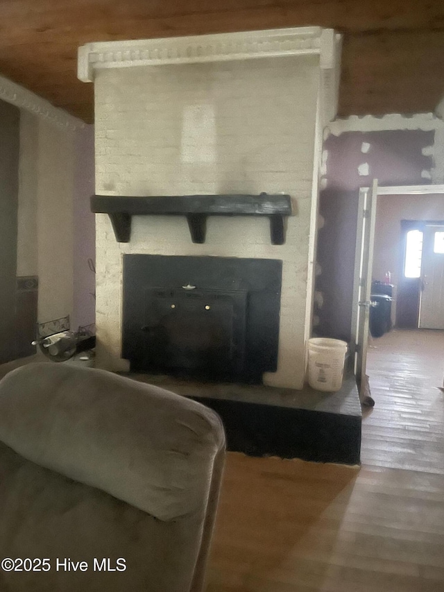 living room featuring a stone fireplace and wood finished floors