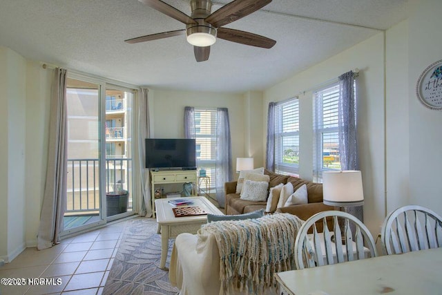 living area featuring a ceiling fan, a textured ceiling, and light tile patterned floors