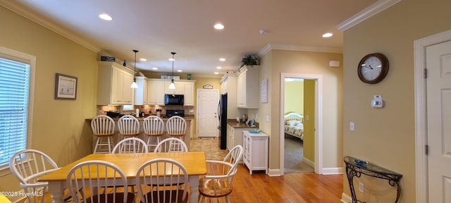 dining room featuring ornamental molding, recessed lighting, light wood-style flooring, and baseboards