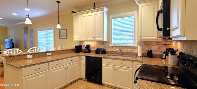 kitchen featuring decorative light fixtures, a peninsula, black appliances, white cabinetry, and a sink