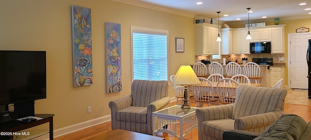 interior space featuring baseboards, light wood finished floors, recessed lighting, and crown molding