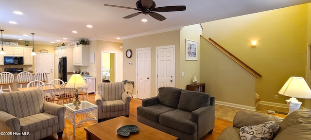 living room featuring baseboards, ceiling fan, ornamental molding, and recessed lighting