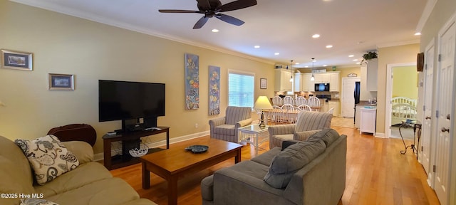 living room with light wood finished floors, recessed lighting, ornamental molding, a ceiling fan, and baseboards