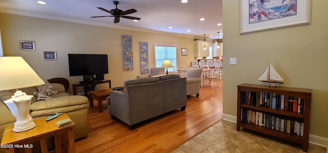living room featuring recessed lighting, a ceiling fan, baseboards, light wood finished floors, and crown molding