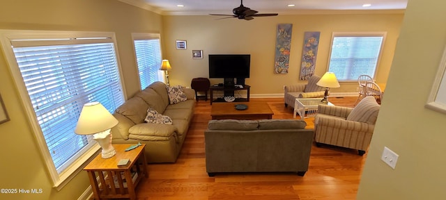 living room with a ceiling fan, crown molding, baseboards, and wood finished floors